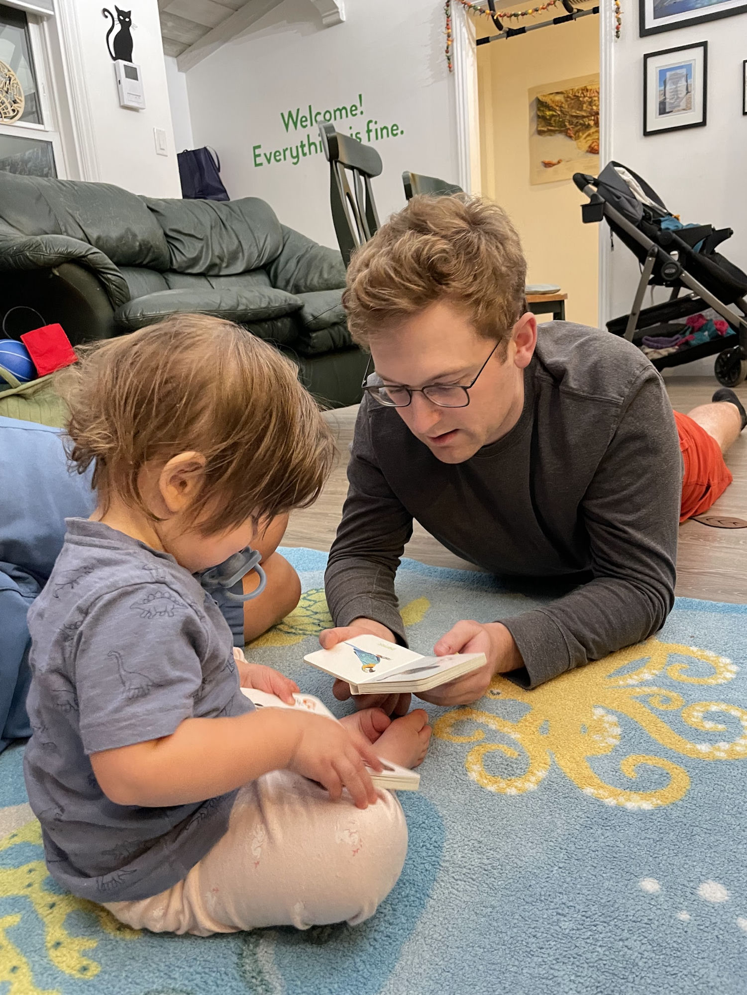Lying on the floor reading a picture book with a toddler